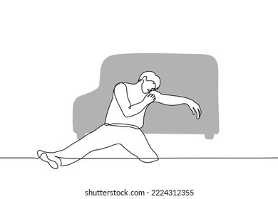 man sits on the floor leaning on a sofa - one line drawing vector. concept fatigue
