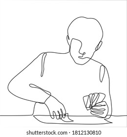 Man sits at a table with cards in his left hand, with his right hand he holds one lying on the table. one continuous line drawing of a man playing solitaire / playing card games / guessing on cards.