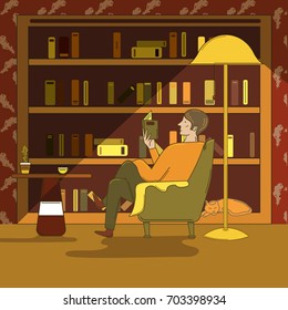 Man Sitting In A Armchair And Reading A Book In Library Room Next To A Lamp, Sleeping Cat And Table.