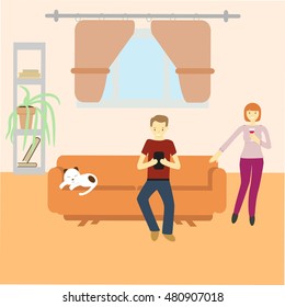 man sitting with gadget on couch and woman standing near the couch at their home with cat sleeping on couch