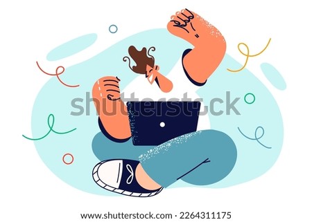 Man sitting on floor with laptop on knees celebrating victory in computer game or sports team winning championship. Guy raises hands up feeling joy of victory after receiving profitable job offer 