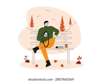 Man sitting on a park bench holding a camera, with a coffee cup and notebook beside him 