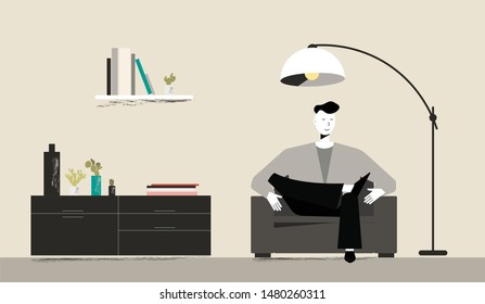 Man sitting on sofa in his living room. Concept of relax after work. Good mood. Books, plants and shelves on background. Floor lamp