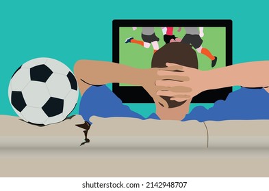 A man sitting on a sofa watching a football match on television