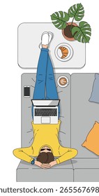 Man sitting on a sofa working on a laptop with his legs crossed over a table with snacks and a plant