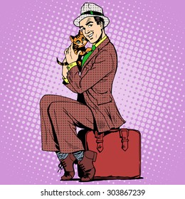 A man sitting on a suitcase holding a kitten. Retro style