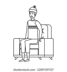 man sitting in sofa with christmas sweater and hat