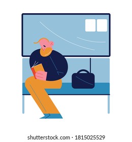 Man sitting in subway coach and reading book near window