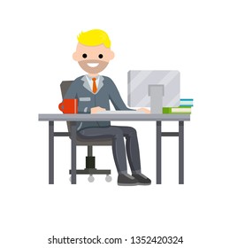 Man sitting at table with computer and typing text message. Employee at work in office. Red coffee mug and books. The guy in the suit and tie. Place of work in the office.