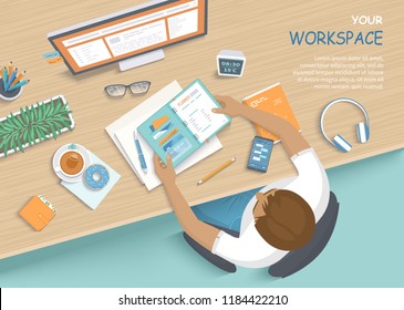 Man sitting at the wooden table. Workplace Desktop Workspace Armchair, office supplies, monitor, books, notebook, headphones, phone, glasses, pen, paper, tea, donuts. Vector Top view 