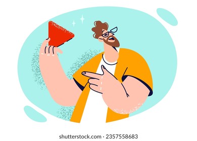 Man with smile points to red triangle symbolizing ban on further movement and call to stop. Young guy in casual clothes demonstrates stop sign urging people to change behavior or plans.