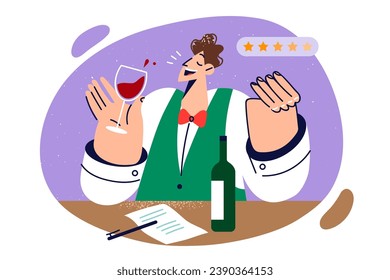 Man sommelier tastes red wine and gives five stars to alcoholic drink likes, standing near table with paper and bottle. Sommelier guy expresses positive feedback after sip wine from sauvignon grapes