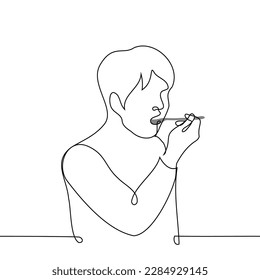 man with a spoon in his mouth - one line drawing vector. the concept of eating or taking medicine