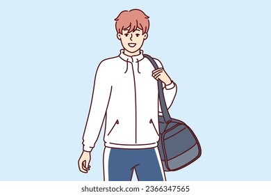 Man sportsman with sportswear bag goes to fitness club or gym and leads healthy lifestyle. Young sportsman professionally involved in football or basketball returns home after training