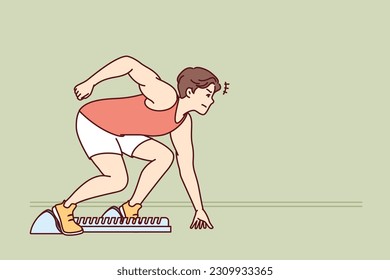 Man sprinter prepares for race standing in starting position in sports stadium. Sprinter athlete participates in running tournament competing with rivals in speed of overcoming distance