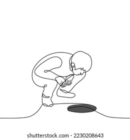 man squatted down and looks into a round hole - one line drawing vector. concept a manhole without a lid, a hole in the ice