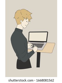 Un hombre de pie trabajando con una laptop 