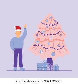 man standing next to chrisrmast tree