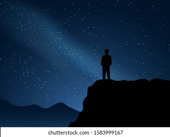 A man standing on mountain watching milky way