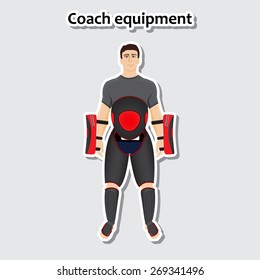 Man standing with sports coach equipment such as shin guard, hip guard and other