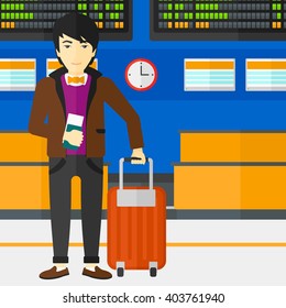 Man standing with suitcase and holding ticket.