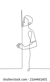 el hombre está parado detrás de la puerta sosteniéndola mirando por algún lado - un vector de dibujo de una línea. supervisión conceptual, vigilancia, observación