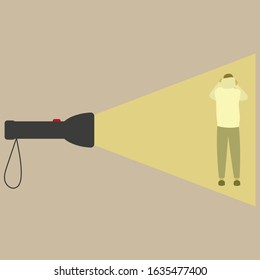 A man stands with his back in the light of a flashlight