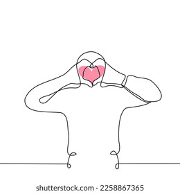 man stands with his hands folded heart shape and shows the viewer - one line drawing vector. love confession concept, korean gesture i love you