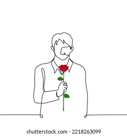 man stands with his head down holding a red rose in front of him - one line drawing vector. concept a delinquent lover asks for forgiveness, a shy admirer gives a flower