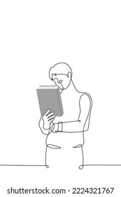 man stands holding a large thick book in his hands and reads the title and author - one line drawing vector. concept buying books