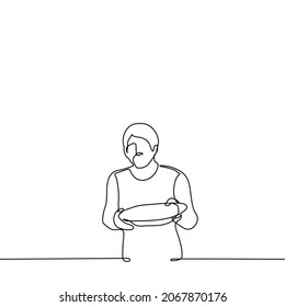 man stands holding out a large empty plate - one line drawing vector. hunger concept; dietary fasting; a beggar or homeless person asks for food 