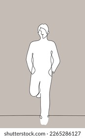 man stands leaning against the wall and his back   feet and his hands in his pockets