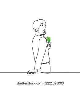 man stands smiling stands with his back holding a bouquet of meadow flowers one line drawing vector. concept man is playful, man loves flowers, man in love