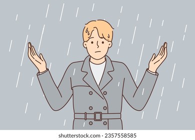 Man stands under rain and spreads arms, stressed due to lack of umbrella and roof over head. Rain is metaphor for problems for businessman suffering from bad environment and beginning of crisis.