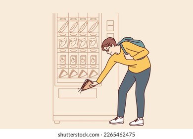 Man student bends down to pick up sandwich while shopping for lunchtime snack from vending machine. Shopper uses automatic vending machine to whet appetite after college or university classes 