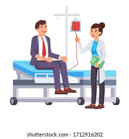 A man in a suit is sitting on the bed and donating blood, nurse, hospital