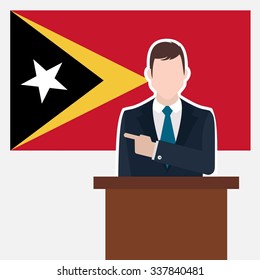 Man in suit standing at rostrum Front of East Timor Country Flag Pointing to the flag. business man Presentation conference concept. Modern flat design vector background illustration. 