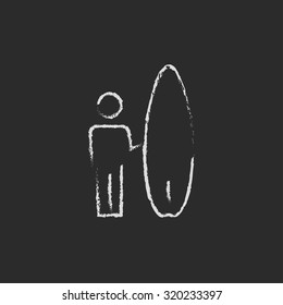 Hombre con una mano de tabla de surf dibujada con tiza sobre un icono blanco vector de pizarra aislado en un fondo negro.