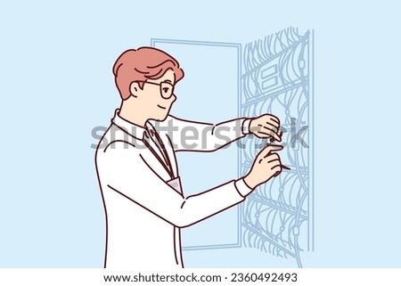 Man system administrator sets up server equipment and connects wires to switches working in hosting company. Guy system administrator is working on connecting high-speed internet in business center