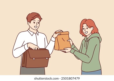 Man takes home-made lunch to work, from hands of loving wife caring for husband. Sandwich bag for delicious lunch for office employee who doesnt want to eat fast food or unhealthy processed foods.