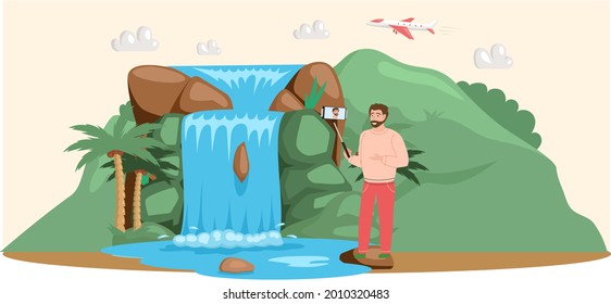 Man takes selfie stands near lake in mountaines landscape with waterfall. Traveler photographing famous landmark in beautiful island in summer vacation. Tourist attraction of wonderful place of visit