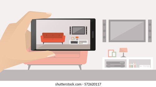 Man taking a picture of his modern living room using his smartphone, point of view