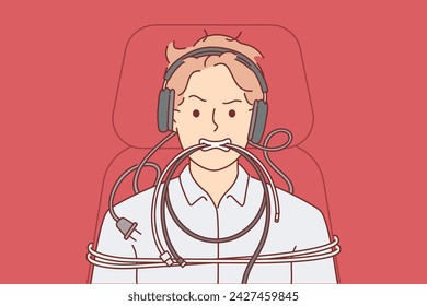 Man is tied up with computer wires and shows aggressive grimace caused by professional burnout. System administrator guy in headphones experiences nervous breakdown and burnout due to difficult work