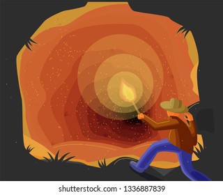 man with a torch in front of a cave