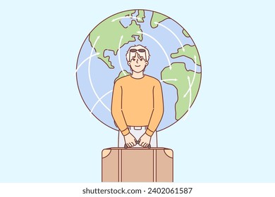 Man tourist holds travel suitcase and prepares for departure standing near planet earth. Guy is going on business travel or wants to immigrate to another country to achieve success in life