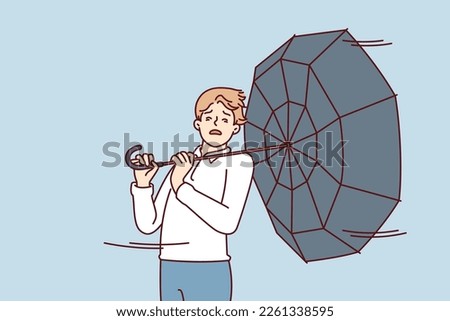 Man with umbrella turned backwards walks down street during severe life-threatening storm. Pedestrian in casual clothes caught in hurricane walking around city and needs shelter