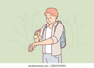 Man uses anti-maskite spray walking in forest or natural park in summer weather. Guy tourist with spray against insect bites and encefalit mites for social advertising about fight with mosquitoes