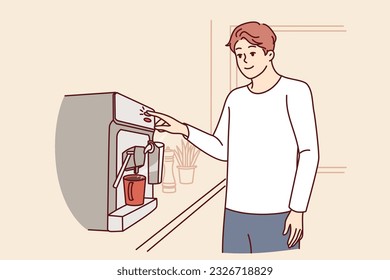 El hombre usa una cafetera parada en la cocina de un apartamento, preparando bebidas para el desayuno vigorizante. El hombre hace café caliente durante el descanso para deshacerse de la somnolencia y ser más productivo