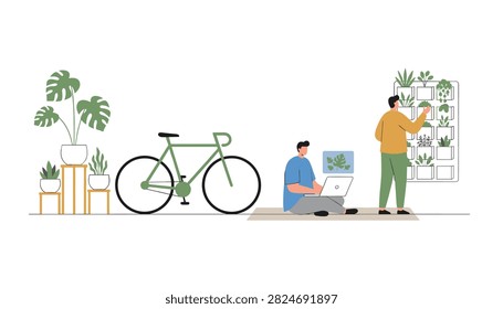 Man using a laptop while another man tends to a vertical garden wall in a bright indoor studio space with plants and bike.