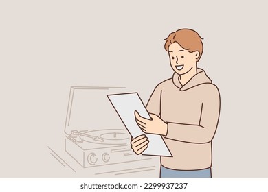 Man with vinyl record stands near gramophone and smiling looks at box of vintage sound recordings from rare collection. Classical music lover guy uses old antique vinyl disk player